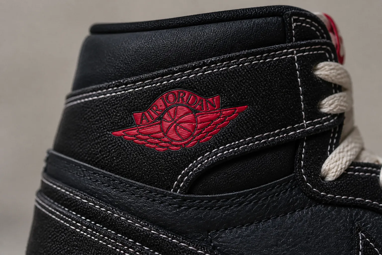 Detailed shot of the embossed Wings logo on the ankle collar with the classic Jumpman branding and red accent stitching