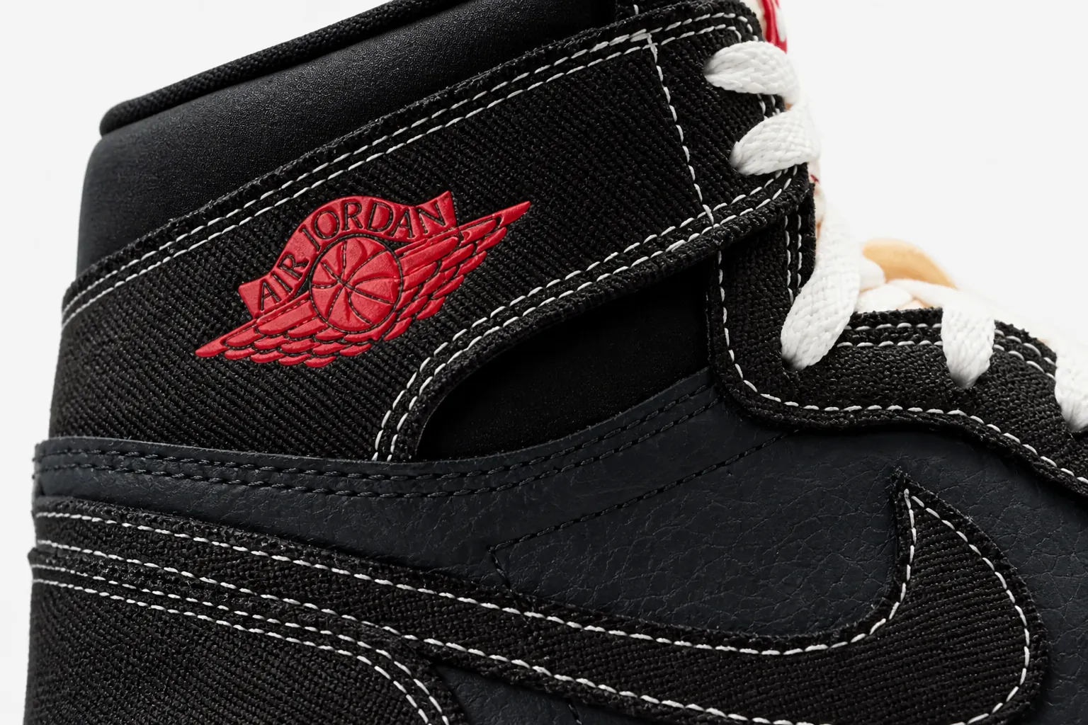 Extreme close-up product shot focusing on the woven textile upper texture with white and University Red accent stitching details and the classic Wings logo