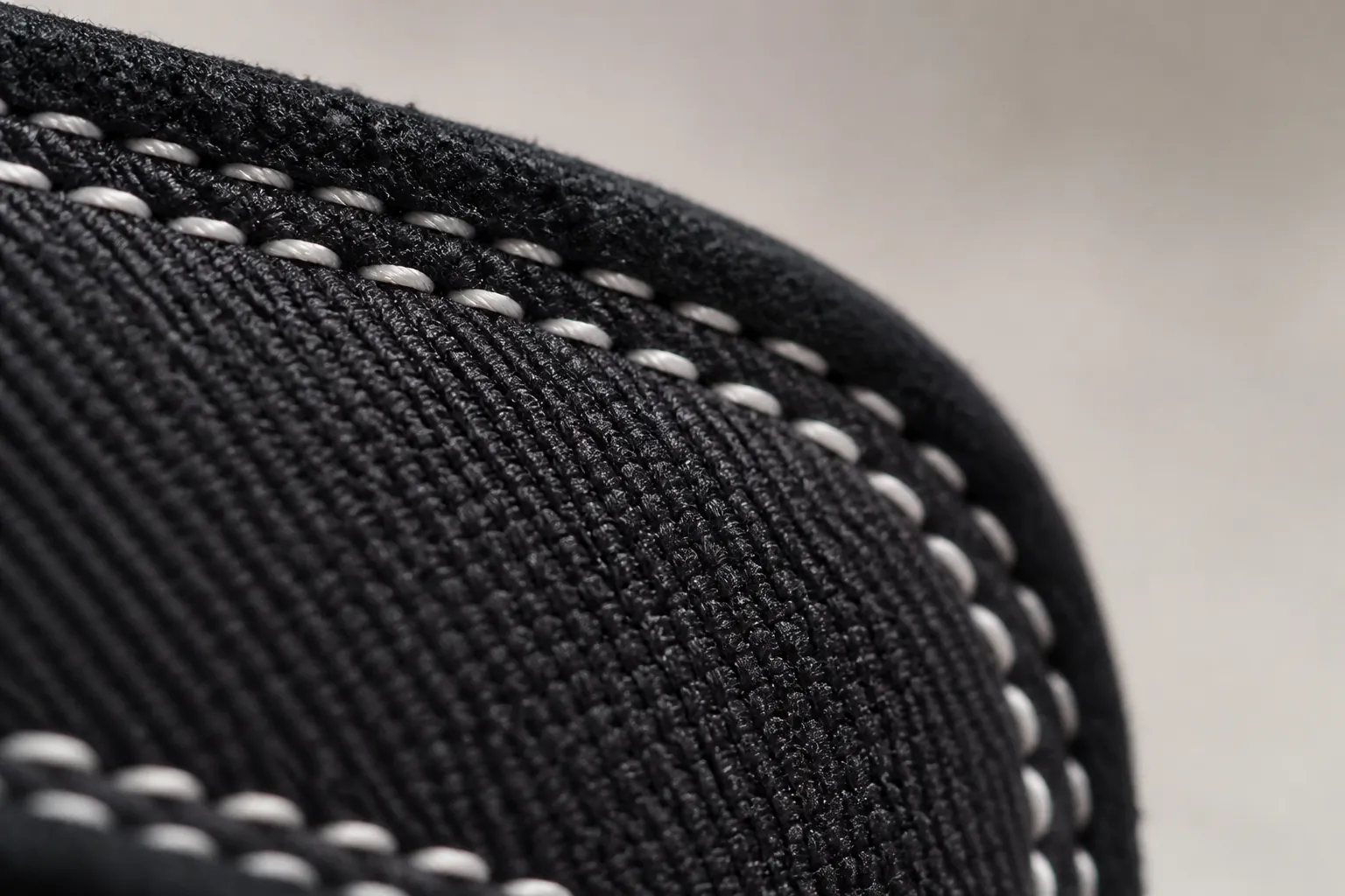 Macro photography of the premium woven textile upper texture showing the intricate black weave pattern with white thread highlights