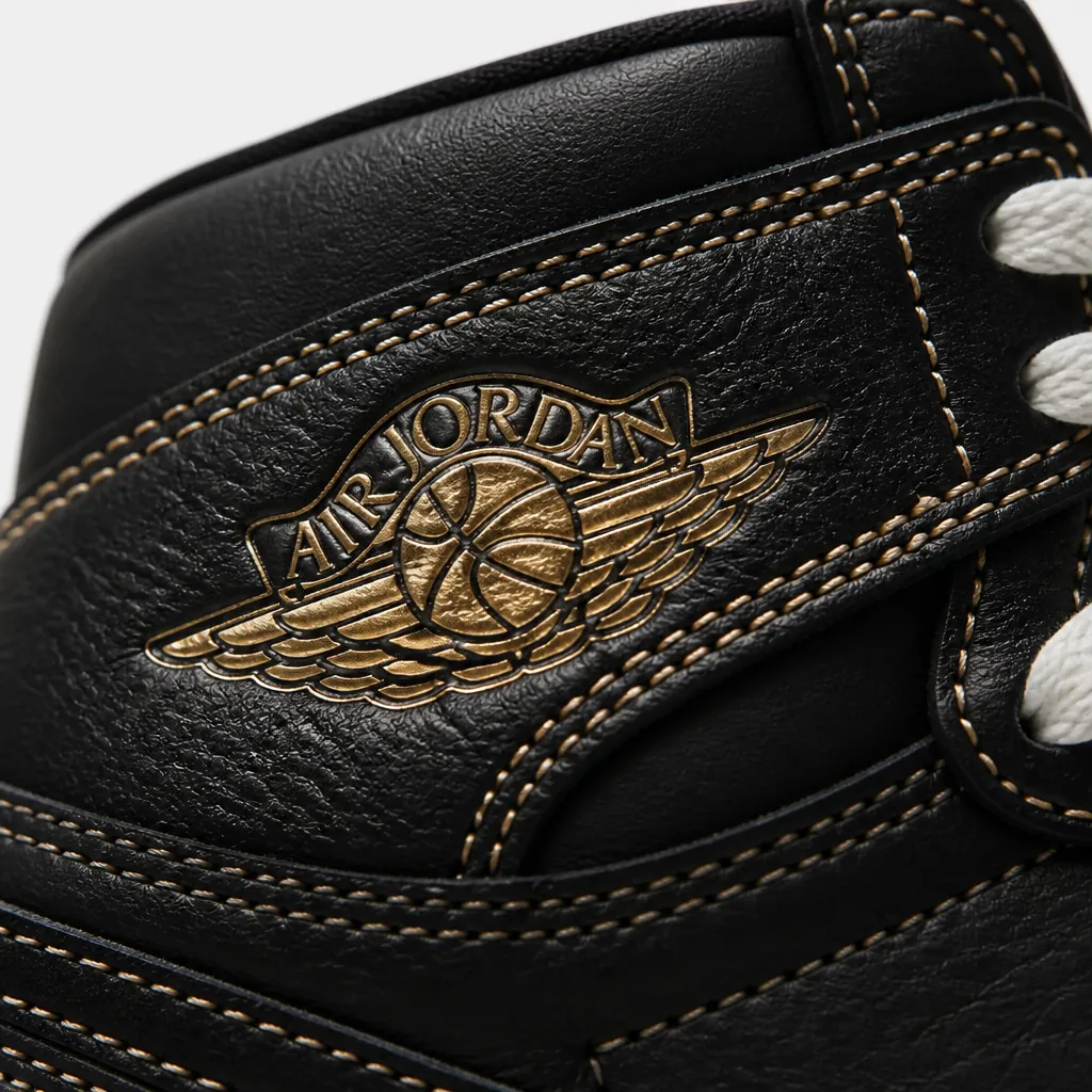 Extreme close-up of the iconic Air Jordan Wings logo embossed on premium leather with gold accent stitching and texture detail