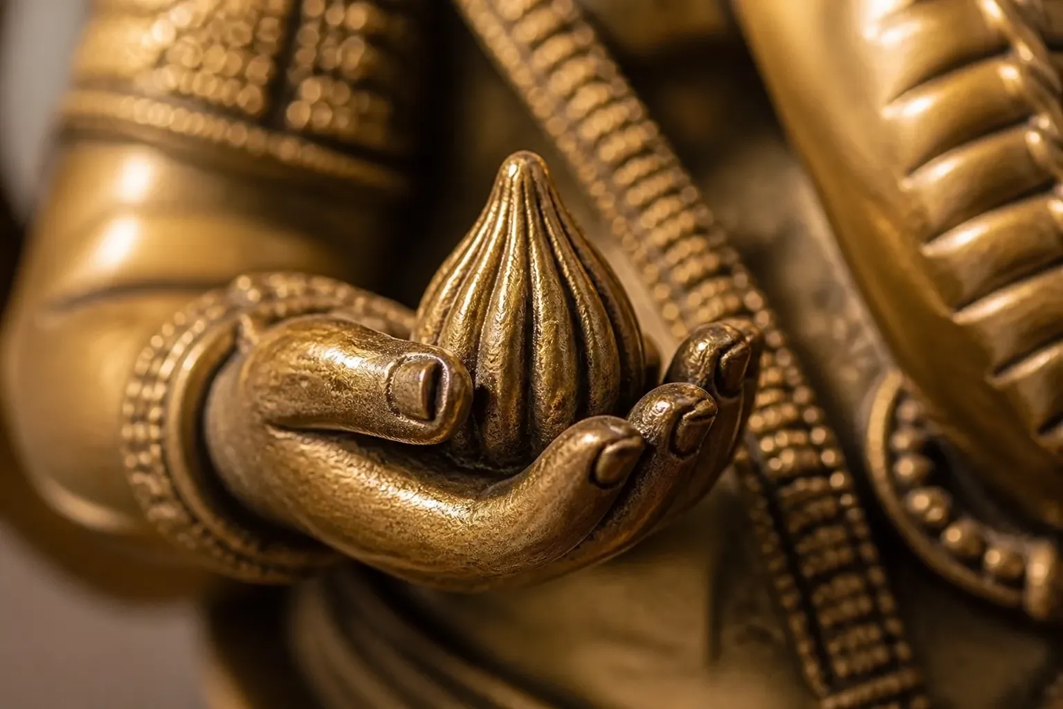 Extreme close-up of the modak sweet held by Ganesha showing intricate carving details