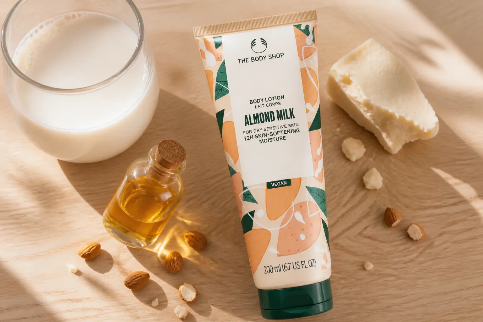 Close-up flat lay photography of fresh almond milk, golden almond oil, and rich shea butter arranged on natural light wood surface with soft morning light