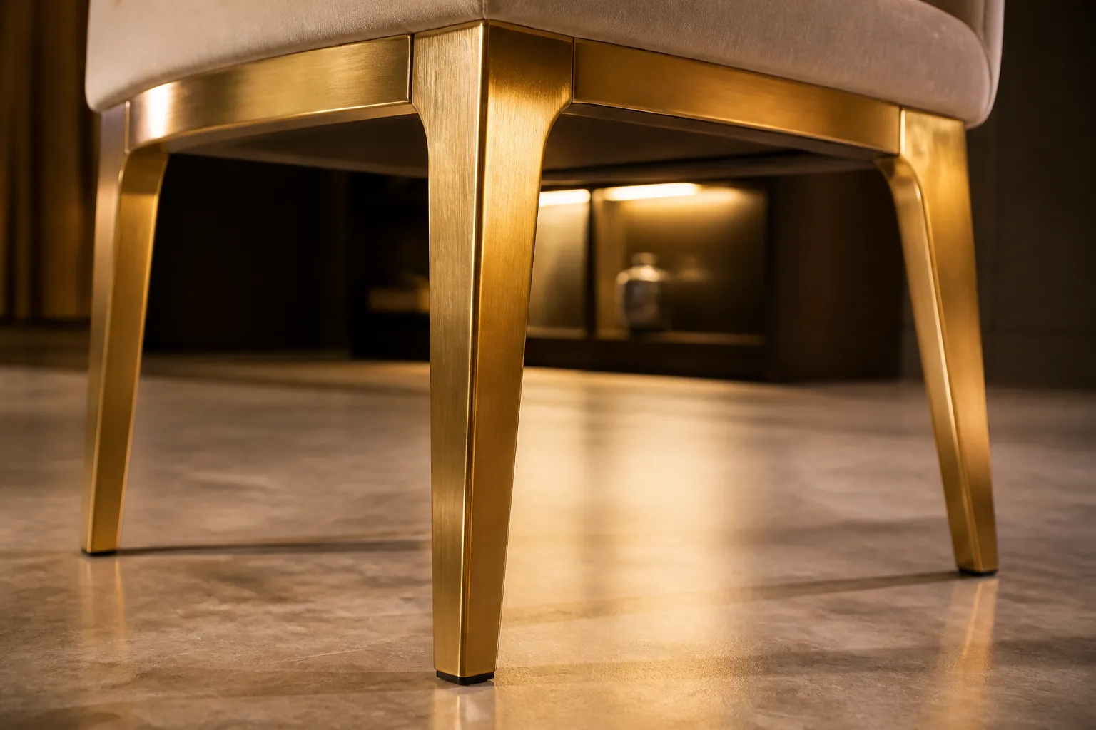 Detail shot of the sturdy metal legs of the Barfi chair showing the sleek modern design and brushed gold finish