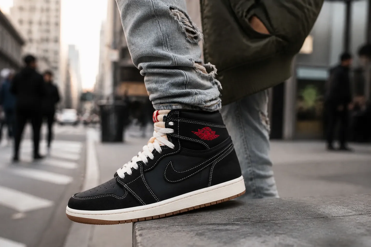 Urban street style featuring the Air Jordan 1 High OG paired with distressed jeans and a bomber jacket in a city setting