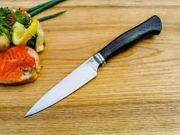 Premium kitchen knife with dramatic lighting showcasing razor-sharp blade