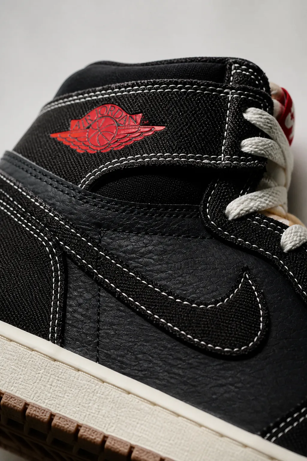 Extreme close-up detail shot of Air Jordan 1 High OG Flight Club showing premium leather texture, precise stitching, and iconic wing logo with dramatic studio lighting