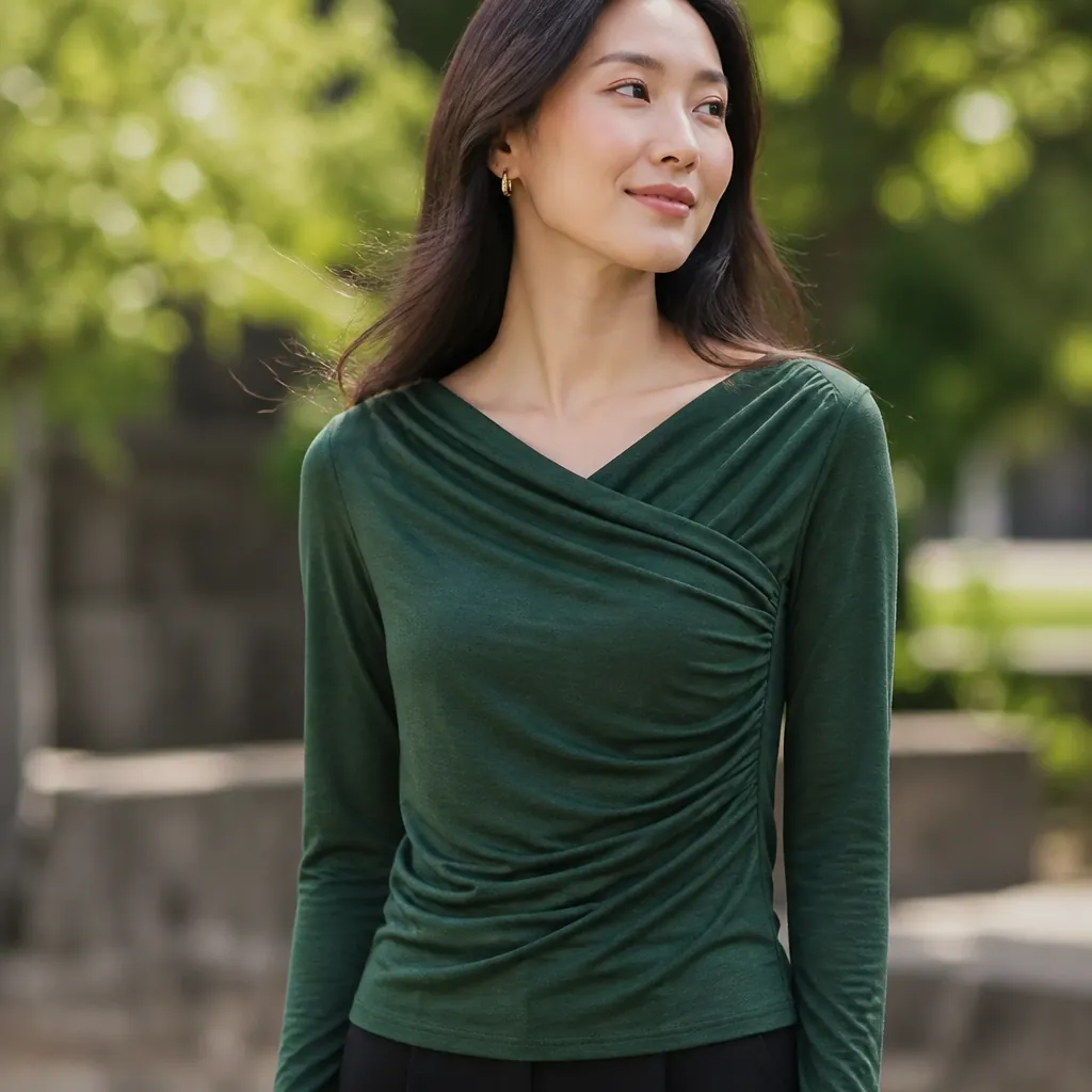 Rich green draped surplice top displayed on model outdoors in natural daylight