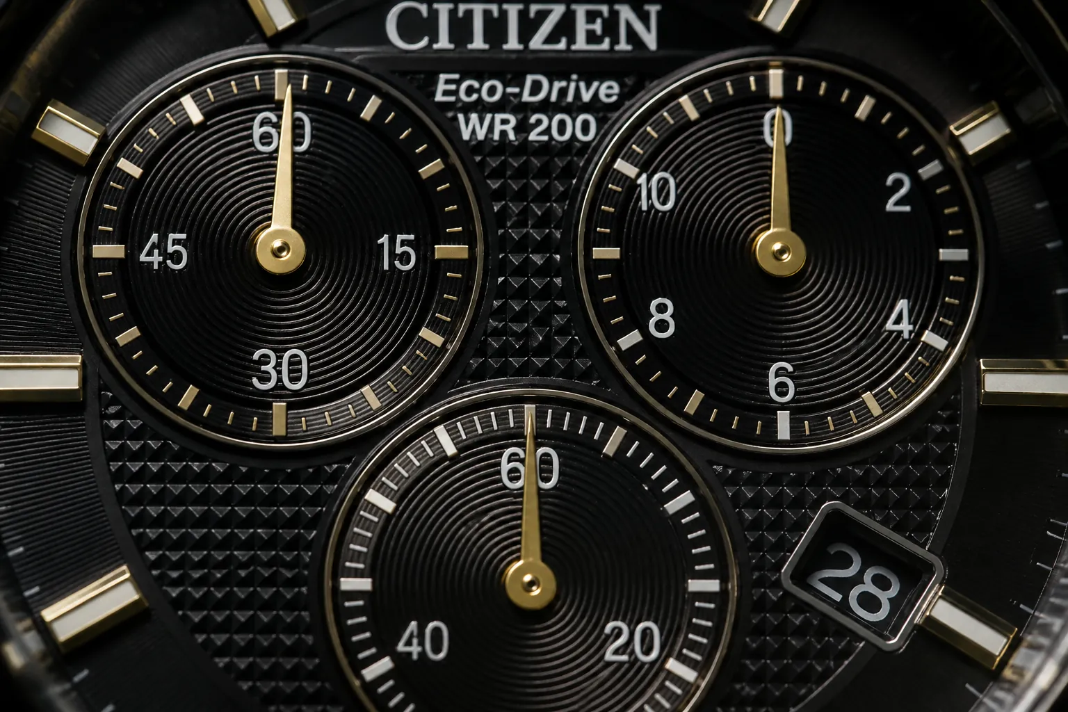 Close-up macro shot of Citizen watch chronograph subdials showing precision timing mechanism with gold hands against black dial