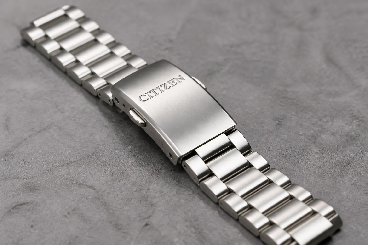 Stainless steel watch bracelet with polished links and fold-over clasp featuring Citizen logo engraved on clasp